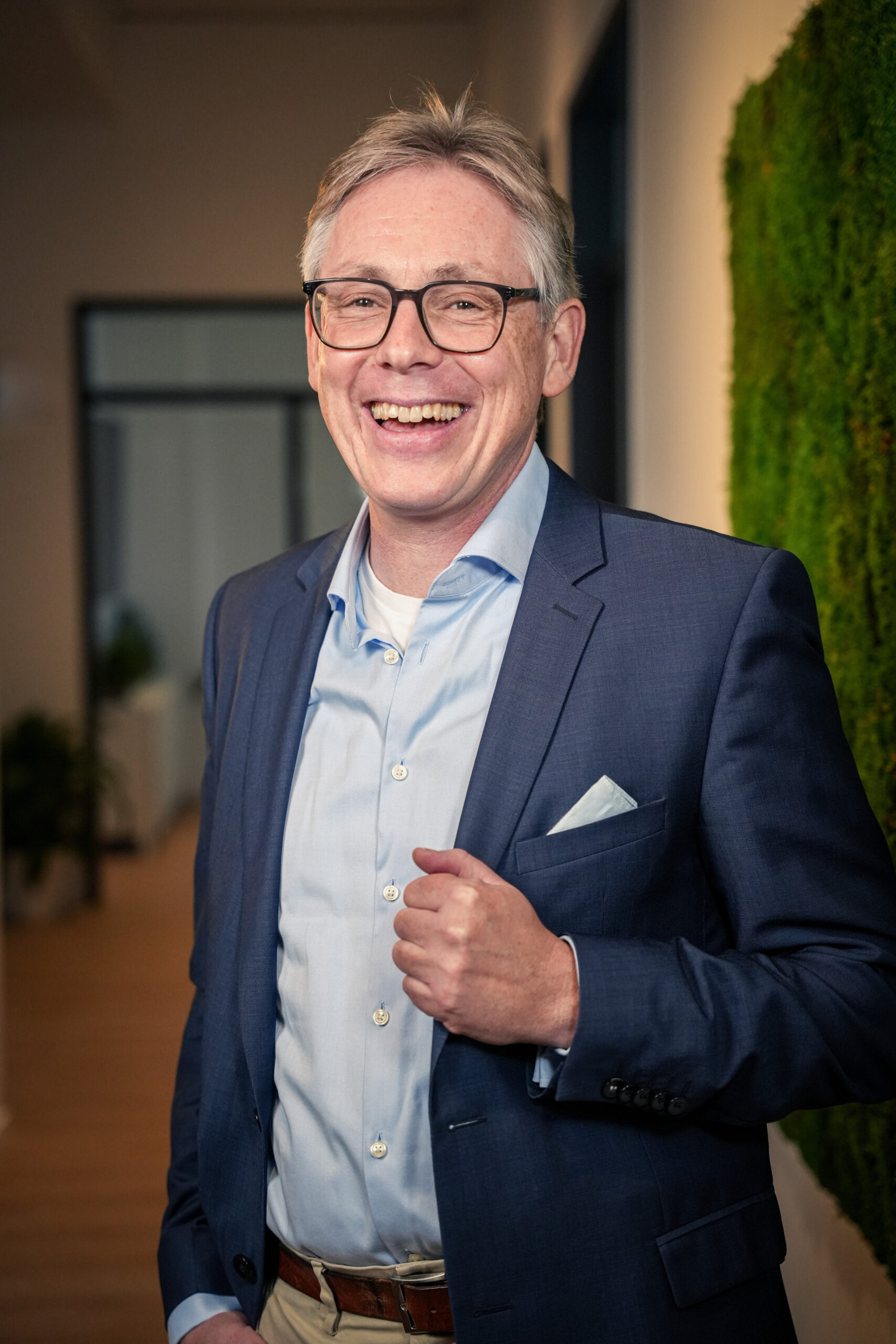 Dirk Wendl, ein Steuerberater für E-Commerce in Köln steht im blauen Anzug in seiner Kanzlei. Er ist der perfekte Ansprechpartner für Themen wie Wohnungskauf steuerlich absetzen, Sonderabschreibung Denkmalschutz, Quellensteuerrückerstattung, ausländische Aktien verkaufen und Dropshipping in Deutschland.